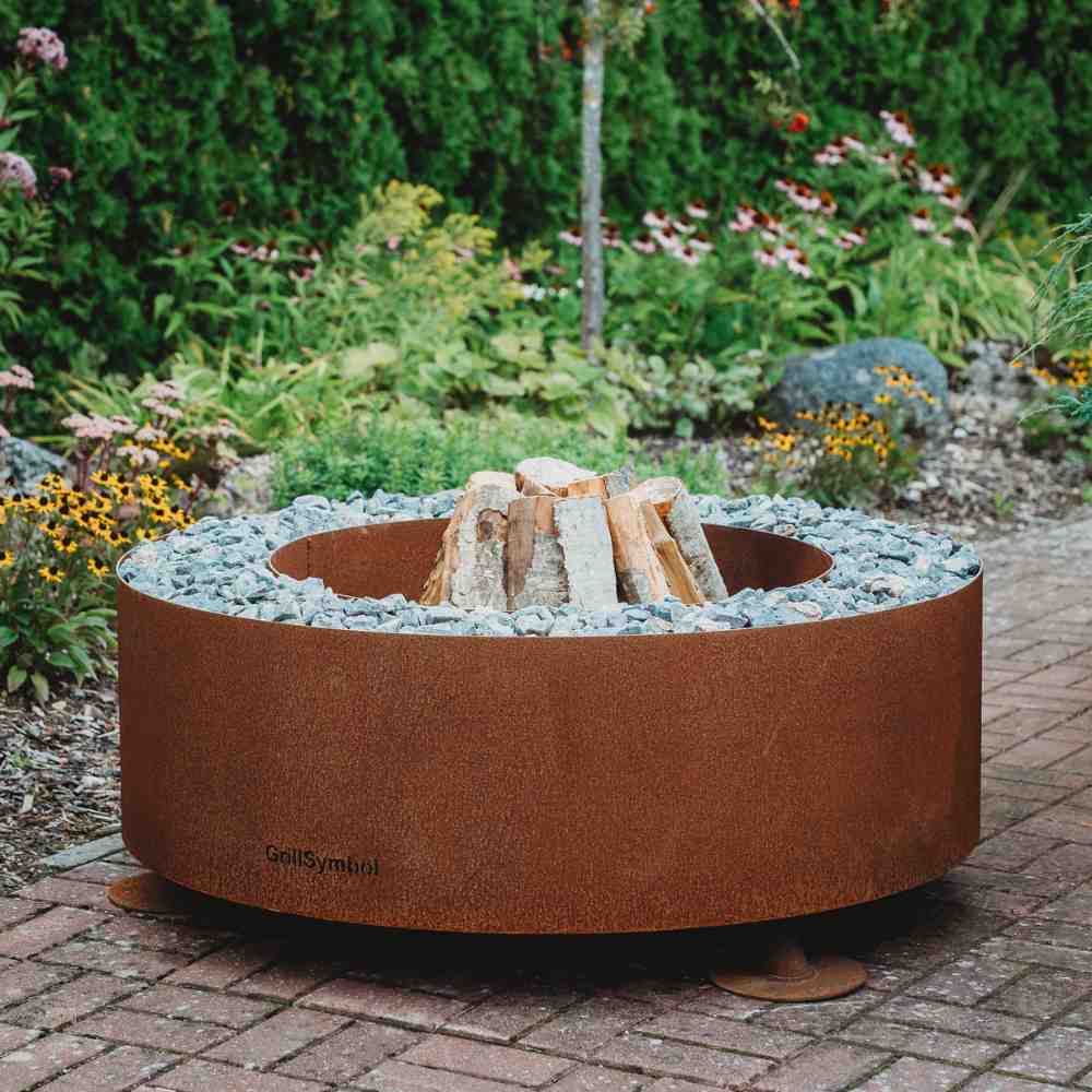 Grillsymbol corten steel fire pit round with small stone surround